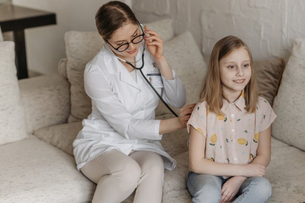 pexels-photo-7653124 Doctor using a stethoscope for a child's check-up on a sofa during a home visit.